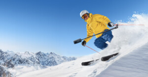 A skier shreds down a snowy mountain slope while holding the Insta360 Ski Pole Mount.